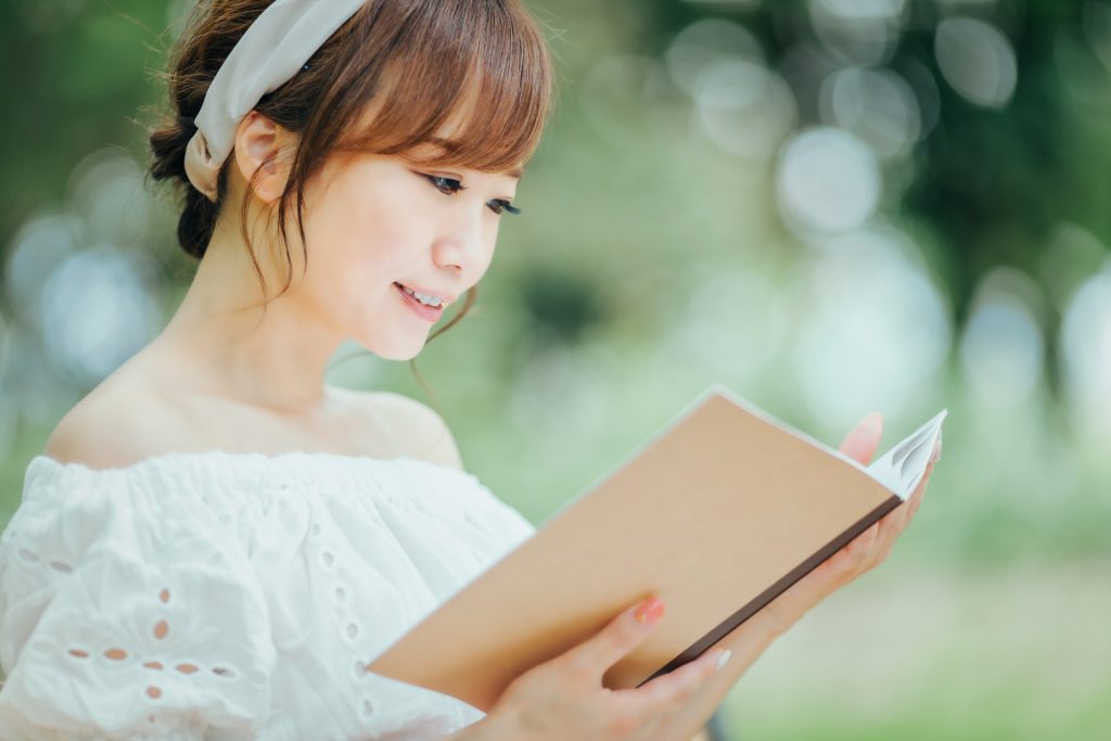 ノートを観ながら笑顔の女性