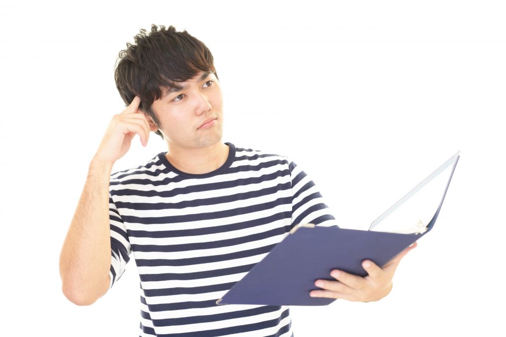 ファイルを持って悩んでいる男性